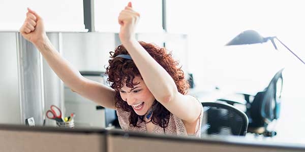 Woman excited sitting in her cube